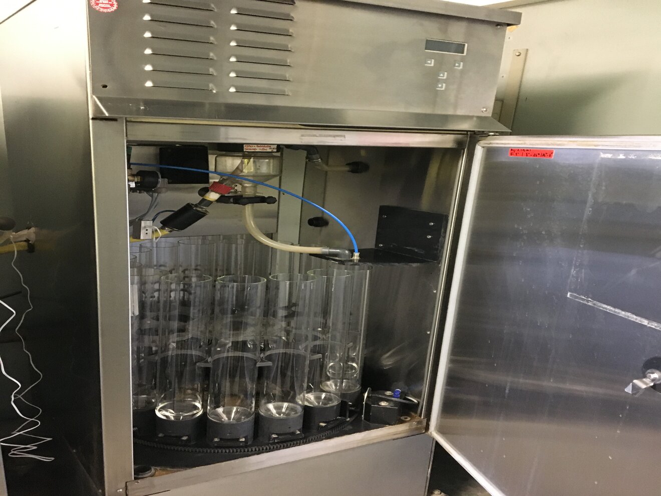 Das Bild zeigt eine Vorrichtung mit Behältern zur automatischen und kontinuierlichen Probenahme innerhalb einer Messstation